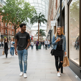 Two people walking on a city street with shops and pedestrians in the background